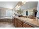 Luxurious bathroom featuring dual sinks, a large mirror, and a relaxing jacuzzi tub at 2069 S Sailors Ct, Gilbert, AZ 85295