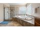 Bright bathroom boasts a glass-enclosed shower, separate soaking tub, and tiled walls at 2069 S Sailors Ct, Gilbert, AZ 85295
