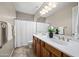 Bathroom featuring double sinks, vanity with wood cabinets, and a shower/tub combo with modern fixtures at 2069 S Sailors Ct, Gilbert, AZ 85295