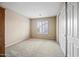 Empty bedroom with neutral carpet flooring, shuttered window, and a closet with sliding doors at 2069 S Sailors Ct, Gilbert, AZ 85295