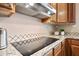 Modern cooktop and hood vent with granite countertops and mosaic tile backsplash at 2069 S Sailors Ct, Gilbert, AZ 85295