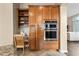 Gourmet kitchen with a built-in desk and stainless appliances, plus custom cabinetry at 2069 S Sailors Ct, Gilbert, AZ 85295