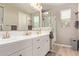 Bright bathroom featuring a double vanity, large mirror, and walk-in shower at 20698 W Meadowbrook Ave, Buckeye, AZ 85396