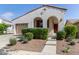 Attractive stucco home with a tile roof, arched entry, front lawn shrubbery, and a convenient two-car garage at 20698 W Meadowbrook Ave, Buckeye, AZ 85396