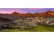 Expansive desert landscape featuring a golf course nestled among the foothills, enhanced by a vivid sunset sky at 20698 W Meadowbrook Ave, Buckeye, AZ 85396
