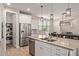 Open kitchen with stainless steel appliances, island with sink, and adjacent dining area at 20698 W Meadowbrook Ave, Buckeye, AZ 85396