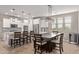 Open-concept kitchen and dining area boasting white cabinets, stainless appliances, and stylish pendant lighting at 20698 W Meadowbrook Ave, Buckeye, AZ 85396