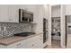 Well-lit kitchen with stainless steel appliances, stylish backsplash, and ample cabinet space at 20698 W Meadowbrook Ave, Buckeye, AZ 85396