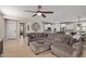 Open-concept living room featuring a large sectional, wood-look tile floors, ceiling fan and an eat-in kitchen at 20698 W Meadowbrook Ave, Buckeye, AZ 85396