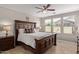 Cozy main bedroom featuring wood flooring, large bed, ceiling fan and natural lighting at 20698 W Meadowbrook Ave, Buckeye, AZ 85396