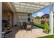 Enjoy outdoor living on this covered patio with a table, seating and backyard views at 20698 W Meadowbrook Ave, Buckeye, AZ 85396