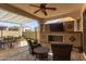 Well-appointed covered patio with outdoor fireplace, seating, and dining area at 20698 W Meadowbrook Ave, Buckeye, AZ 85396