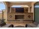 Covered patio with outdoor fireplace, comfortable seating, and decorative accents at 20698 W Meadowbrook Ave, Buckeye, AZ 85396