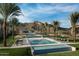 Stunning swimming pool area with mountain views, resort-style lounge chairs, and swaying palm trees under a blue sky at 20698 W Meadowbrook Ave, Buckeye, AZ 85396