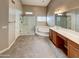 This bathroom features a soaking tub, glass shower, double sink vanity and neutral colors at 2088 N 164Th Ave, Goodyear, AZ 85395
