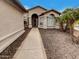 Charming home exterior featuring an arched entryway, stone accents, and desert landscaping at 2088 N 164Th Ave, Goodyear, AZ 85395