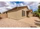 A tan home exterior featuring a cozy covered patio and low-maintenance landscaping at 20941 E Pecan Ln, Queen Creek, AZ 85142