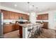 Spacious kitchen with wood cabinets, stainless steel appliances, granite counters, an island and bar stool seating at 20941 E Pecan Ln, Queen Creek, AZ 85142