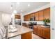 Modern kitchen featuring a large island, stainless steel appliances, wood cabinets and stone countertops at 20941 E Pecan Ln, Queen Creek, AZ 85142