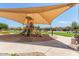 Community playground with a large shade canopy, slides, and a seating bench at 20941 E Pecan Ln, Queen Creek, AZ 85142