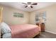 Bedroom with ceiling fan, wood-look floors, two windows, and antique-look bed frame at 2131 W Verde Ln, Phoenix, AZ 85015