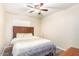 Comfortable bedroom with wood-look floors, ceiling fan, and wooden slat headboard at 2131 W Verde Ln, Phoenix, AZ 85015
