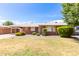 Charming brick home with a well-maintained lawn, rock landscaping, and mature shrubbery under a bright blue sky at 2131 W Verde Ln, Phoenix, AZ 85015