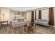 Cozy living room featuring wood-look floors, comfortable sofas, and a dining area at 2131 W Verde Ln, Phoenix, AZ 85015