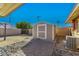 Backyard storage shed, offering secure storage space, with brick-paved pathway and easy access from the yard at 2131 W Verde Ln, Phoenix, AZ 85015