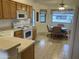 Well-lit kitchen with oak cabinetry, white appliances, and an adjacent dining area, perfect for casual meals and gatherings at 2152 S Olivewood --, Mesa, AZ 85209