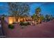 Inviting backyard with covered patio, fire pit, desert landscaping, and palm trees under a twilight sky at 22912 N San Ramon Ct, Sun City West, AZ 85375