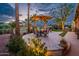 Charming backyard with a shaded dining area, swaying palm trees, and a peaceful view of the golf course at 22912 N San Ramon Ct, Sun City West, AZ 85375