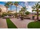 Outdoor living at its finest with a built-in fire pit, manicured grass, and a dining area with an umbrella at 22912 N San Ramon Ct, Sun City West, AZ 85375