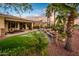 Spacious backyard with a built-in barbecue area, lush landscaping, a fire pit, and a shaded dining area at 22912 N San Ramon Ct, Sun City West, AZ 85375