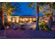 Expansive backyard at twilight, featuring a built-in fire pit, desert landscaping, and serene patio areas at 22912 N San Ramon Ct, Sun City West, AZ 85375