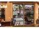 A view of the backyard fire pit and outdoor seating area from inside, visible through sliding glass doors at 22912 N San Ramon Ct, Sun City West, AZ 85375