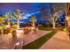 Beautifully landscaped backyard with a fire pit, lush lawn, and stunning views of the golf course beyond at 22912 N San Ramon Ct, Sun City West, AZ 85375