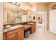 This primary bathroom features dual sinks, ample granite counter space, a seated vanity, and tiled floors at 22912 N San Ramon Ct, Sun City West, AZ 85375