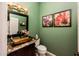 Stylish half bathroom featuring green walls, granite countertops, and an elegant vessel sink at 22912 N San Ramon Ct, Sun City West, AZ 85375