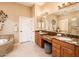 Well-lit bathroom with granite countertops, dual sinks, tub, and vanity seating at 22912 N San Ramon Ct, Sun City West, AZ 85375