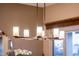 Contemporary dining area chandelier featuring a linear design with cylindrical lamp shades and sleek metal finish at 22912 N San Ramon Ct, Sun City West, AZ 85375
