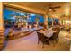 Elegant covered patio featuring stone pillars, a dining area, an outdoor kitchen and a view of the fire pit at 22912 N San Ramon Ct, Sun City West, AZ 85375