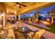 Relaxing covered patio with comfortable seating, fan, stone pillars, and views of outdoor living spaces at 22912 N San Ramon Ct, Sun City West, AZ 85375