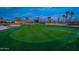 Lush green golf course with well-maintained fairway, sand trap, and surrounding houses at twilight at 22912 N San Ramon Ct, Sun City West, AZ 85375
