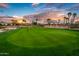 Lush green golf course with manicured putting green, flag, and scenic views of surrounding neighborhood at 22912 N San Ramon Ct, Sun City West, AZ 85375