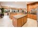 Gourmet kitchen with center island, granite countertops, and seamless flow to dining area at 22912 N San Ramon Ct, Sun City West, AZ 85375