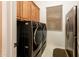 Functional laundry room with modern washer and dryer, cabinets, and a stainless-steel refrigerator at 22912 N San Ramon Ct, Sun City West, AZ 85375
