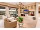 Bright living room featuring modern decor, custom built-ins, and views of the outdoor landscape at 22912 N San Ramon Ct, Sun City West, AZ 85375