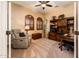 Office space features a comfortable recliner, built-in shelving, and natural light at 22912 N San Ramon Ct, Sun City West, AZ 85375