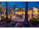 Charming covered patio featuring an outdoor dining set, surrounded by lush landscaping and mature palm trees at 22912 N San Ramon Ct, Sun City West, AZ 85375